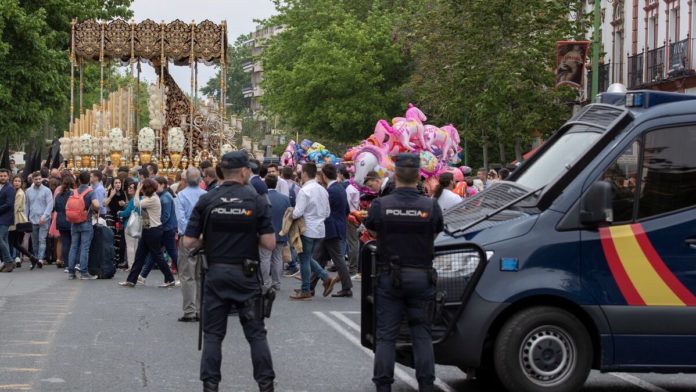 Policías nacionales protegen el paso de la Virgen del Refugio por la Puerta de la Carne / EFE
