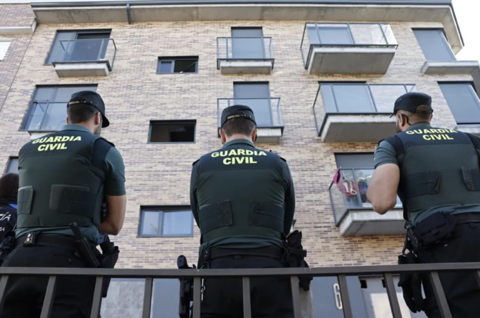 Agentes de la Guardia Civil frente a un edificio de viviendas