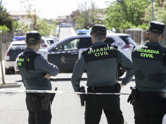 Tres agentes de la Guardia Civil frente a un inmueble acordonado